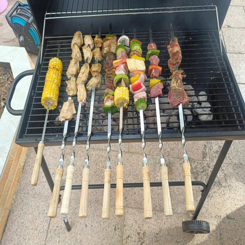 22 Inch Stainless Steel Flat Kabob Skewers With Wooden Handles 12 Pack Reusable Shish Kebab Sticks For Meat Shrimp Chicken Vegetables And Sausage Heavy Duty BBQ Grill Skewers displayed on a grill with mixed foods.