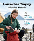 Person packing Beast Portable 88.8Wh Power Station With 110V AC Outlet And Lithium Battery into a red backpack near campsite.