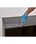 Applying The Game Changer Polycrylic Protective Finish Spray For Interior Wood Projects on a dark wood surface with a brush.