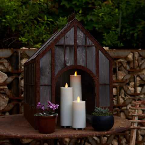 Outdoor Slim Pillar Flameless Led Candles Set Of 3 Ivory With Moving Flame Weather Resistant Remote Timer Ready Battery Operated Safe Melted Edge No Fuss Low Maintenance Glow For Porch Or Patio displayed in a mini greenhouse setting.