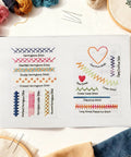Embroidery Stitch Book Kit With 106 Patterns, Complete Toolkit And Step By Step Tutorial displayed on open page with colorful threads.