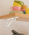 Heavy Duty Corner Shelf Brackets Wall Mount Supports Rock Solid Iron L Brackets Built Like A Tank For Diy Wood Shelving And Workshop Storage Super Sturdy Black Metal Braces Zero Stress Setup with a white metal bracket.