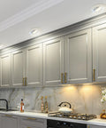 Big Time Brightness Rotatable Led Retrofit Downlight Gimbal illuminating modern kitchen cabinetry with gold accents.