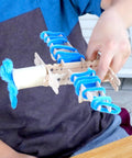 Child creating toy airplane with DIY Arts And Crafts Starter Kit Mega Box With Pounds Of Craft Supplies For Kids Ages Four Through Twelve