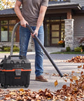 Heavy Duty 4 Gallon Wet Dry Shop Vacuum With 5.5 Peak HP Blower Function being used to clean leaves outdoors.
