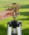 Close-up of Heavy Duty Zinc Alloy Impact Sprinklers 2 Pack with hand adjusting the spray settings in a garden setting.