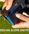 Close-up of Golf Rangefinder With Wind Speed And Slope Compensation Link X3 Plus being held, showing the locking slope switch.