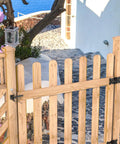 Heavy Duty Self Latching Gate Hook With Spring Release Cable on wooden gate, providing security for outdoor space.