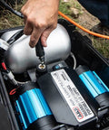 Heavy Duty Road Trip Ready 12 Volt Twin Motor Portable Air Compressor With Integrated Aluminum Tank and quick connection in use.