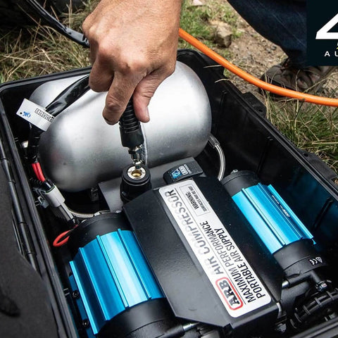Heavy Duty Road Trip Ready 12 Volt Twin Motor Portable Air Compressor With Integrated Aluminum Tank and quick connection in use.