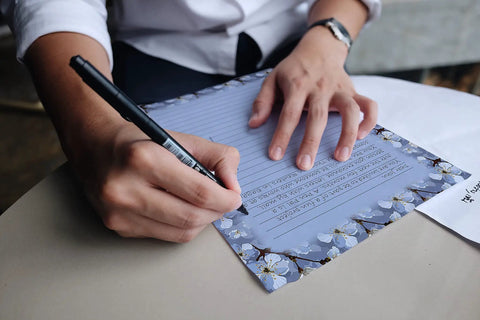 Person writing on Vintage Airmail Themed Stationery Set With 100 Pieces Letter Size 8.5 By 11 Inches Including 50 Lined Sheets