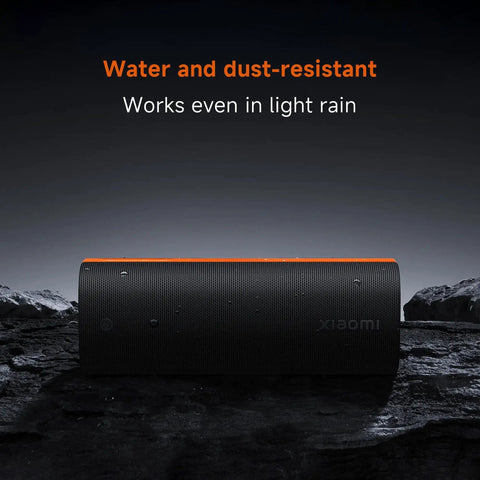 Boom Out Loud Party Bluetooth Speaker 50W Power, Waterproof Portable Wireless Audio, 26 Hour Playtime For Outdoor Ragers Sync Up To 100 Units Super Cool Design on a rocky surface with water droplets.