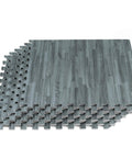 Stack of interlocking foam floor tiles 3/8 inch thick with slick wood grain look, anti fatigue mats, slate color, 24x24 inches.