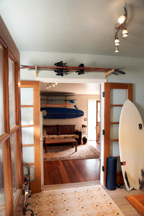 Top Shelf Heavy Duty Bamboo Ski Wall Mount Rack For Garage Storage holding skis above doorway in a stylish indoor space.