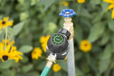 High Flow Metal Watering Timer With Twenty Percent More Water Flow Than Standard Timers attached to outdoor faucet with flowers