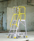 Top Shelf Heavy Duty Aluminum Rolling Platform Ladder With Smooth Glide Casters And Reinforced Safety Rails 375 Lb Capacity in industrial setting.
