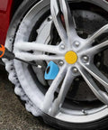 Six Piece Car Wheel Polishing Kit With Foam Cones And Balls One Quarter Inch Hex Extension Holder Pro Grade Dope Buffing Pads For Rims Hubs Exhaust Tips Aluminum And Chrome Metal Polishing Tools being used on a tire rim with foam cleaner
