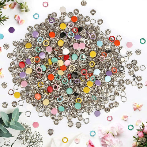Assorted colorful and metallic snap buttons spread out, part of the Must Have Metal Snap Buttons Kit With Fastener Pliers Press Tool For DIY Crafts.