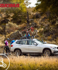Rooftop Upright Bike Mount Carrier For Wheelbases Up To 52 Inches on car roof with cyclists nearby, outdoors in park