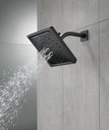 Matte Black Universal Shower Arm Replacement For RP6023BL With Durable Brass Build Easy Install And Universal Fit For Most Shower Faucets Finish Guaranteed Lifetime Warranty Dope Upgrade For Any Modern Bathroom, installed with square shower head spraying water on tiled wall.