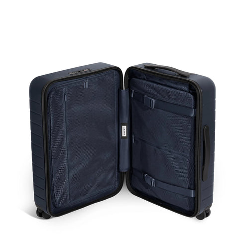 Open view of Bigger Carry On Luggage From Away, lightweight hardside large suitcase with spacious interior and navy polycarbonate shell.