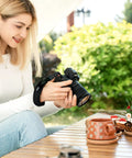 Person using Quick Release Soft Neoprene Camera Hand Wrist Grip Strap for Lightweight DSLRs and Mirrorless Cameras with 7mm by 3mm Eyelet.