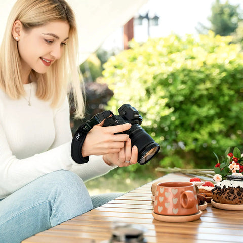 Person using Quick Release Soft Neoprene Camera Hand Wrist Grip Strap for Lightweight DSLRs and Mirrorless Cameras with 7mm by 3mm Eyelet.