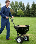 Person using Beast Of A Heavy Duty Walk Behind Lawn Spreader With 80 Lb Capacity, 12 Foot Spreading Width, on green lawn