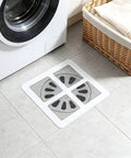Hair Drain Stickers 100Pcs Disposable Self Adhesive mesh filter placed on tiled floor near washing machine.