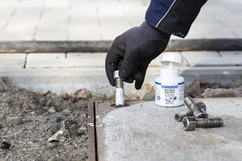 Hand applying Anti Seize High Tech Assembly Paste 450 G Metal Free High Temperature Resistant For Corrosion Protection