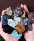 Hands holding colorful 3 Pound Bulk Rough Madagascar Stones Mix For Tumbling Cabbing And Polishing Natural Raw Crystals