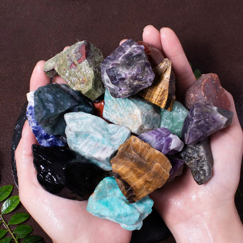 Hands holding colorful 3 Pound Bulk Rough Madagascar Stones Mix For Tumbling Cabbing And Polishing Natural Raw Crystals