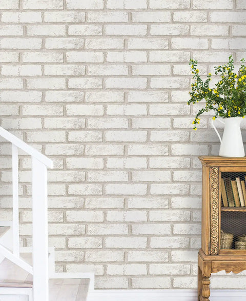 White and beige faux brick wall with greenery vase beside staircase, showcasing Peel And Stick Faux Brick Wallpaper Self Adhesive White And Beige Roll 17.7 By 472.4 Inches Removable Wall Covering For Bedroom And Laundry Room Accent Walls Easy Install No Glue Needed.