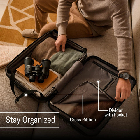 Person organizing Samsonite hard shell carry-on luggage with cross ribbons and dividers.