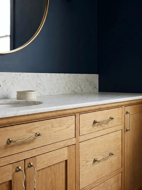 Brushed Antique Brass Wavy Cabinet Pulls With Five Inch Hole Centers on wooden bathroom cabinets under marble counter