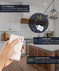 Hand holding Battery-Free DIY Wireless Light Switch Kit With 150Ft RF Range Self-Powered By Kinetic Energy in a kitchen.