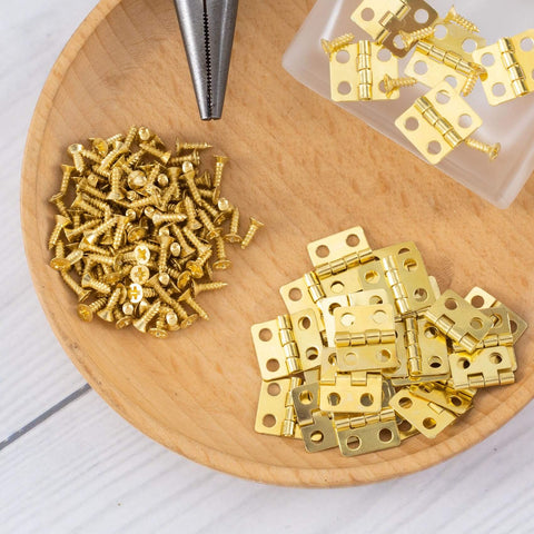 Thirty Pieces Small Brass Hinges For Crafts With 120 Screws And Nails, 13 X 12 Mm on wooden plate for DIY projects.
