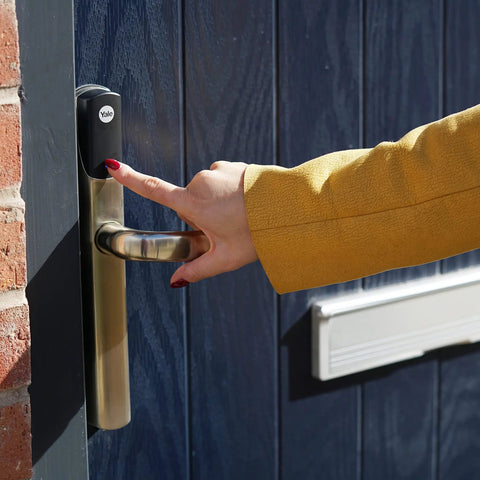 Person using No Sweat Smart Keyless Front Door Handle With Polished Brass Finish and Smartphone App Control.