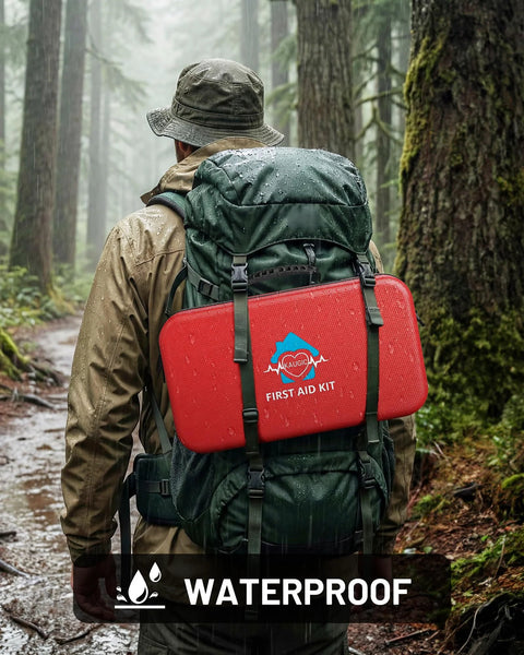 Back view of a red waterproof first aid kit attached to a green hiking backpack with straps in a forest