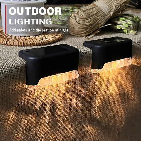 Close-up of two solar lights from 20 Pack LED Outdoor Solar Lights For Deck Fence Steps And Patio, waterproof warm white 3000K.