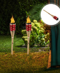 Two Pack Red Tiki Torch Oil Lamps For Outdoor Garden Pathway Lighting And Party Decor Durable Woven Torches With Red Dye Easy Install Weather Resistant Backyard Party Ready Lighting For Festivals And Celebrations displayed in garden.