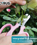 Person using 7.5 Inch Garden Shears Pruner Secateurs with Integrated Stab Remover for flowers, ergonomic pink handle visible. 