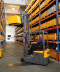 Super Reliable Electric Seated Forklift With 3300 Pound Capacity lifting a yellow box in a warehouse aisle.