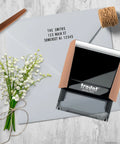 Badass DIY Self Ink Stamp Kit With Swap Out Character Panels And Tweezers Designed For Quick Return Address Stamping Small Business Parcel Or Thank You Card Layouts on an envelope with flowers.