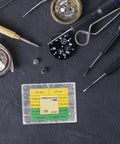 No Sweat Heavy Duty Stainless Steel Watch Screws Assortment Set on workbench with various watch repair tools.