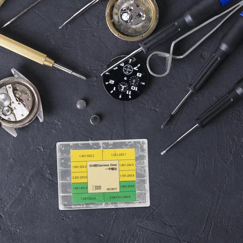 No Sweat Heavy Duty Stainless Steel Watch Screws Assortment Set on workbench with various watch repair tools.