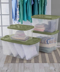 120 Qt Big Boy Storage Bin, Clear Plastic Tote With Green Lid, stacked with blankets and clothing, heavy duty handles, ideal for dorm and closet organization.