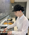 Top Shelf Three Pack Chef Hats For Women And Men With Brimmed Elastic Fit Breathable Poly Cotton Kitchen Cooking Caps For Restaurant Shifts And Weekend Cookouts, black chef hat worn by woman in kitchen.