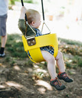 Toddler using Toddler Zip Line Seat For Backyard Fun, Weatherproof Plastic Seat With Soft Rubber Coated Cable And Wood Cross Support