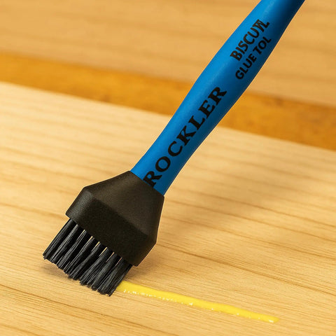 Blue Easy Clean Silicone Glue Spreader for Biscuit Joinery with dual end applying glue on wood surface, close-up